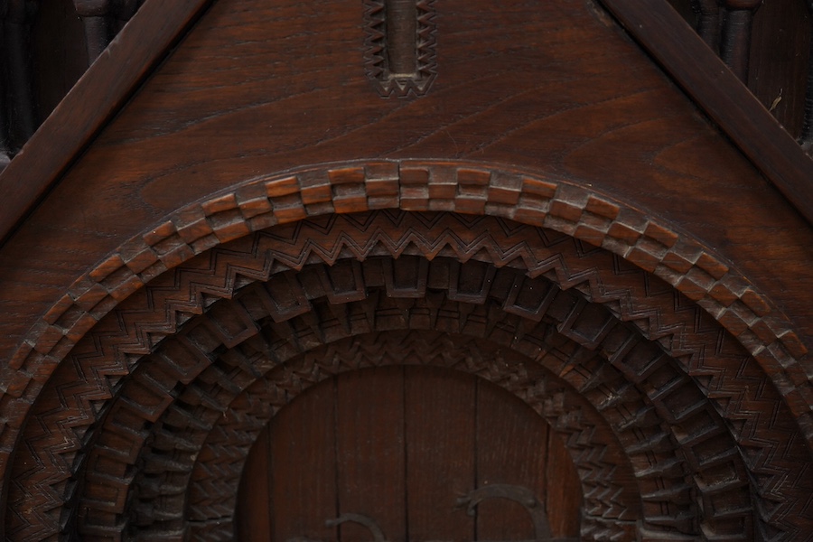 A carved oak firescreen in form of a Norman Romanesque church door and frontage Height 69cm. Width 62cm. Condition - fair